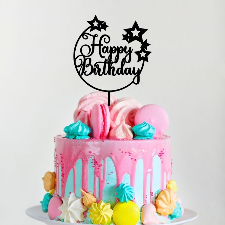 Ornate black acrylic cake topper saying Happy Birthday created by That Aussie Handmade Place sitting on a colourful cake
