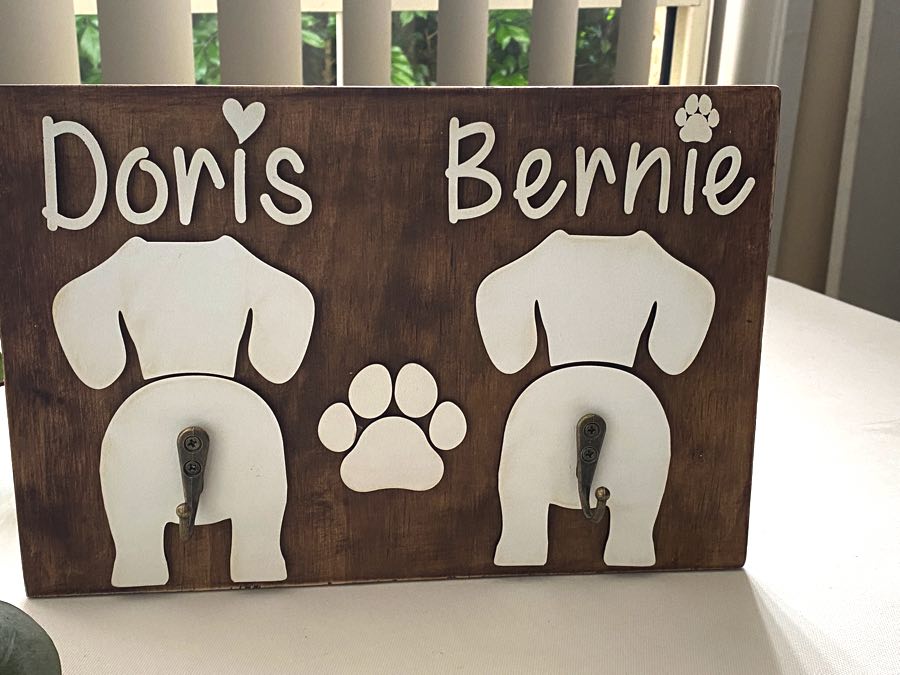 Double Dog Leash Holder in Timber with white names and dog butt silhouettes.