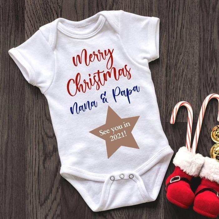 This is a white baby onesie with Merry Christmas Nana & Papa on it with a star underneath saying See you in 2021.  Sold by Bubs and Bobbins