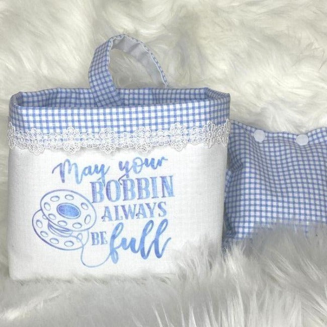 This is a pretty blue and white check thread catcher with matching pin cushion by Bubs and Bobbins.  It is trimmed with lace  and has a transfer on the front saying "May your bobbin always be full"